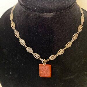 Ornate silver necklace with buddha pendant